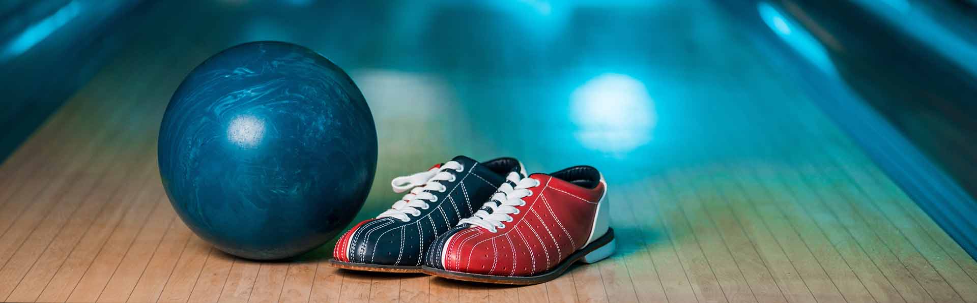Bowlingklot och skor står på en bowlingbana
